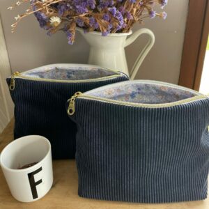 pochette zippée en velours côtelé bleu marine et motif intérieur fleurs